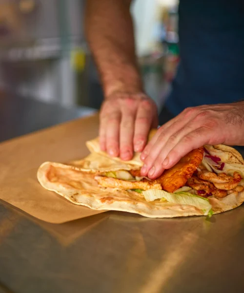 close-up-of-man-making-takeaway-wrap-in-food-van-a-2024-10-22-09-36-12-utc